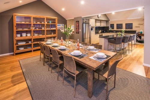 a dining room with a long wooden table and chairs at Top of the Hill in Yallingup
