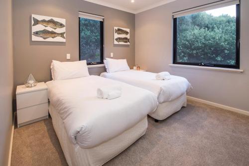 two beds in a room with two windows at Top of the Hill in Yallingup