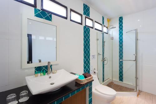 un bagno con lavandino, wc e doccia di Phi Phi Long Beach Resort & Villa a Phi Phi Don