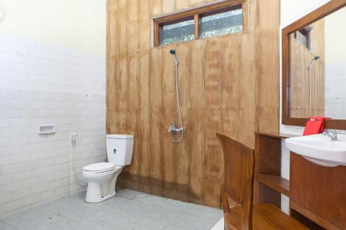 a bathroom with a shower and a toilet and a sink at RedDoorz near Baluran National Park in Pandean