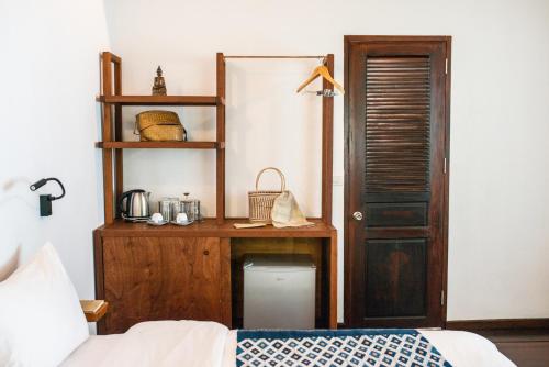 a bedroom with a bed and a wooden desk at Residence Bassac in Champasak
