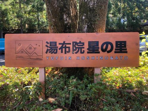 a sign for a museum in front of a tree at Yufuin Hoshinosato in Yufuin