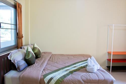 a bed sitting in a room with a window at Akantuka Homestay in Chanthaburi