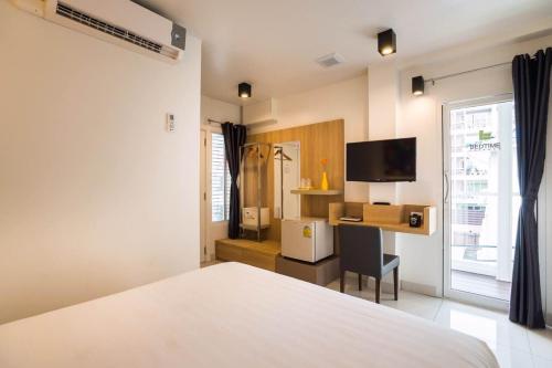 a bedroom with a bed and a desk and a television at Bedtime Pattaya in Pattaya