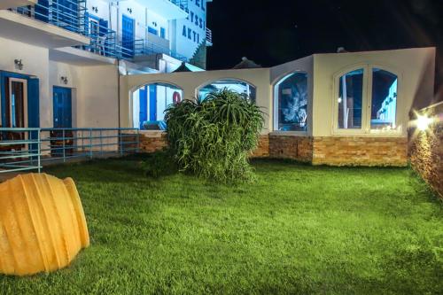 a house with a green lawn in front of it at Chryssi Akti, Sure Hotel Collection in Batsi