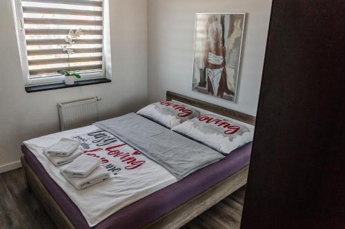 Una cama con toallas en una habitación en Apartamenty Balbina 1, en Tychy