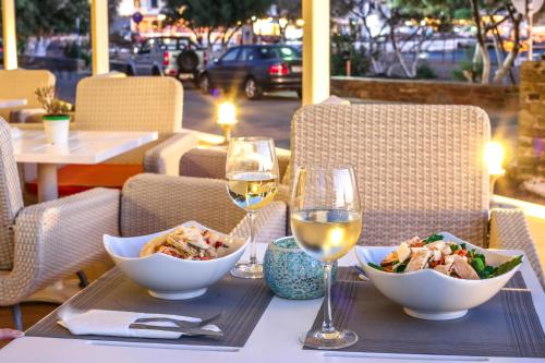 a table with a bowl of food and a glass of wine at Chryssi Akti, Sure Hotel Collection in Batsi