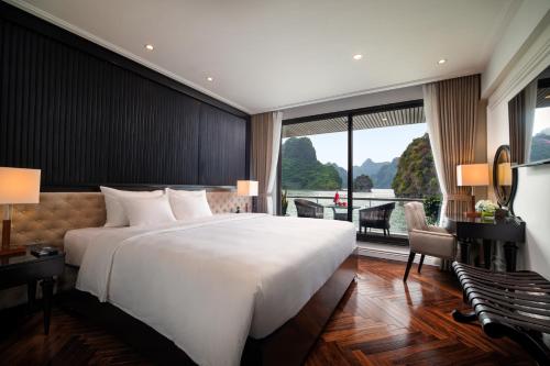 a bedroom with a large white bed and a balcony at Stellar of the Seas Cruise in Ha Long