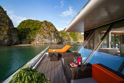 a boat deck with a table and chairs on the water at Stellar of the Seas Cruise in Ha Long
