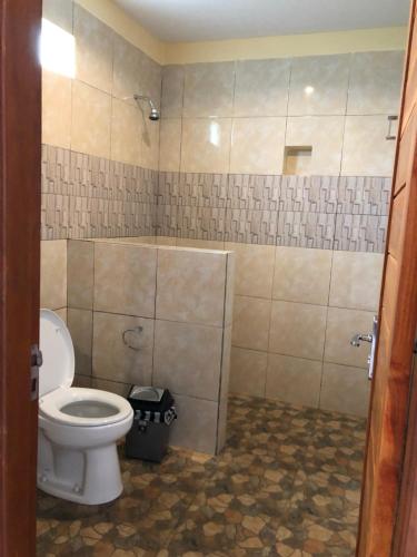 a bathroom with a toilet and a shower at Cantika Guest House in Uluwatu