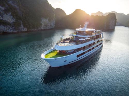 a cruise ship in the water near some cliffs at Stellar of the Seas Cruise in Ha Long