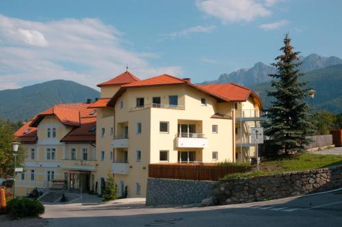 uma casa grande com telhados vermelhos numa colina em Hotel Kronplatz em Valdaora