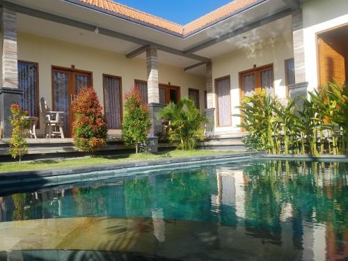 una villa con piscina di fronte a una casa di Cantika Guest House a Uluwatu