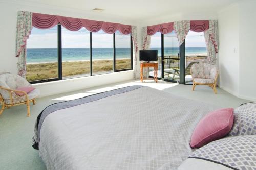 a bedroom with a bed and a view of the ocean at Bayside Beauty in Busselton