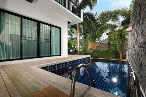 a house with a swimming pool next to a building at Thaimond Residence by TropicLook Walkable distance to Naiharn beach in Nai Harn Beach
