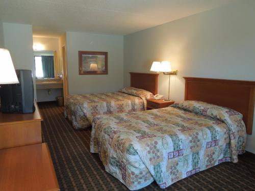 a hotel room with two beds and a flat screen tv at Atlantic Inn in Millsboro