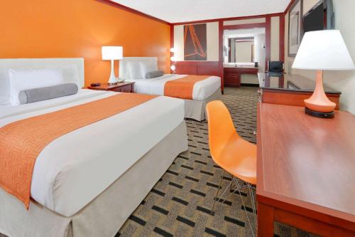 a hotel room with two beds and a desk at Howard Johnson by Wyndham San Marcos in San Marcos