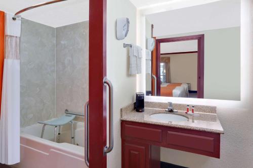 a bathroom with a sink and a tub and a mirror at Howard Johnson by Wyndham San Marcos in San Marcos