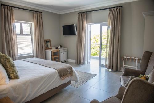 a bedroom with a bed and a sliding glass door at The Whale on Main B&B in Hermanus