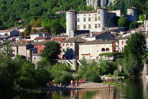 a group of people on the shore of a river with a castle at Suite Nid d'Amour et Spa privatif in Vogüé