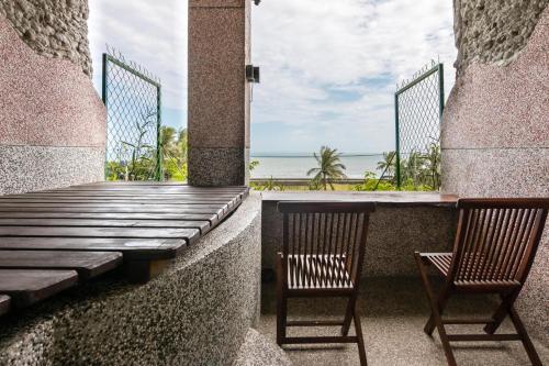 two chairs on a porch with a view of the ocean at Pasa in Fushan