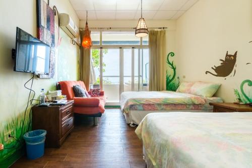 a room with two beds and a tv and a chair at Pasa in Fushan