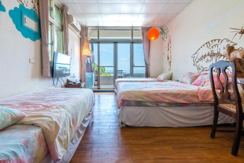 a bedroom with two beds and a tv and a balcony at Pasa in Fushan
