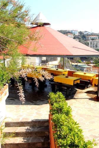 a patio with benches and tables and a building at Hotel Baia Del Sorriso in Castiglioncello