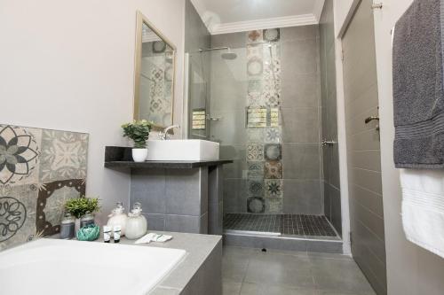y baño con lavabo y ducha. en Hillside Guesthouse Umhlanga, en Durban