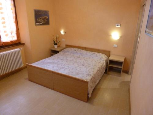 - une petite chambre avec un lit et deux tables dans l'établissement Casa Giardinetto, à Stresa