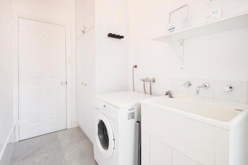 a white laundry room with a sink and a washing machine at Buxton Thomas in Dunsborough