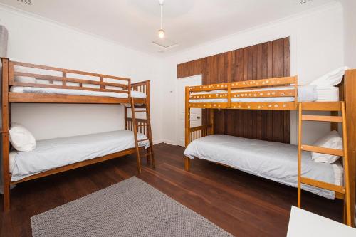 two bunk beds in a room with wooden floors at Buxton Thomas in Dunsborough