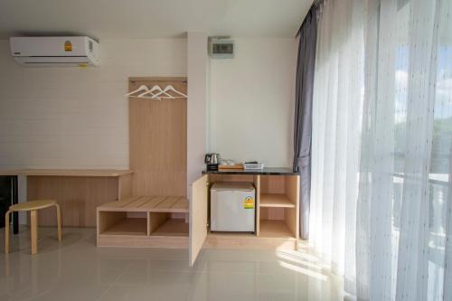a room with a small table and a window at Happiness Guesthouse in Pak Chong