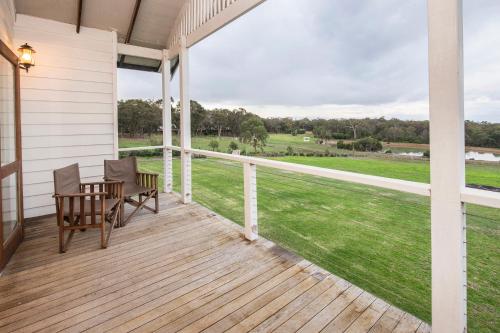 a porch with a table and chairs and a view of a field at Buxton Thomas in Dunsborough