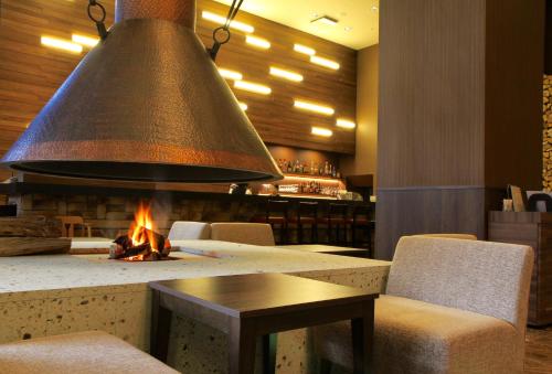 a large bell hanging over a fireplace in a restaurant at Karuizawakurabu Hotel 1130 Hewitt Resort in Tsumagoi