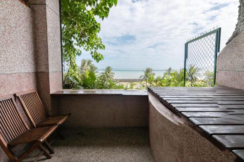 a balcony with a bench and a view of the beach at Pasa in Fushan