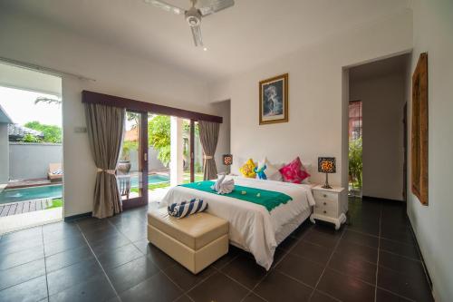 Un dormitorio con una cama y una piscina. en Casa Priya Canggu, en Canggu