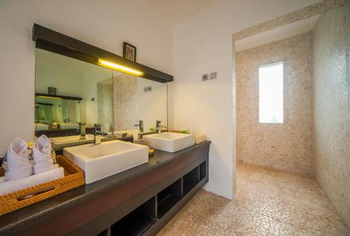 Un baño con dos lavabos y un espejo grande. en Casa Priya Canggu, en Canggu
