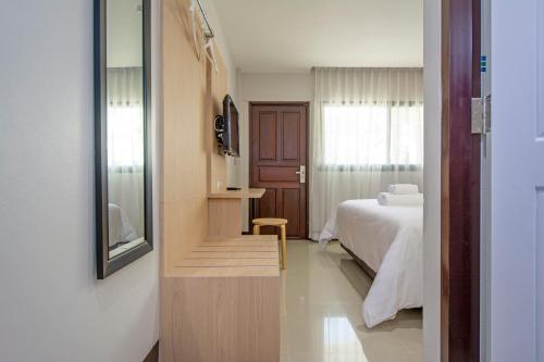 a hotel room with a bed and a mirror at Happiness Guesthouse in Pak Chong