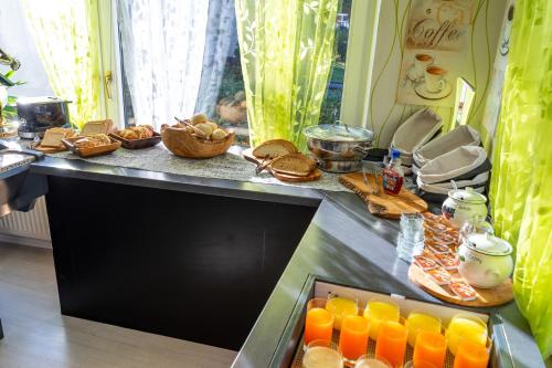a counter with a bunch of food and orange juice at Hotel Rosengarten in Schwäbisch Gmünd