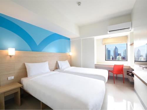a hotel room with two beds and a desk at Hop Inn Hotel Tomas Morato Quezon City in Manila