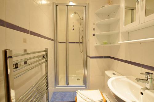 W łazience znajduje się prysznic, toaleta i umywalka. w obiekcie ALTIDO Classic 2BR Apartment with Castle Views in Old Town w Edynburgu