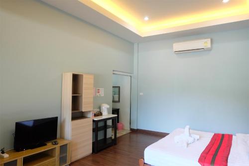 a bedroom with a bed and a flat screen tv at Akantuka Homestay in Chanthaburi