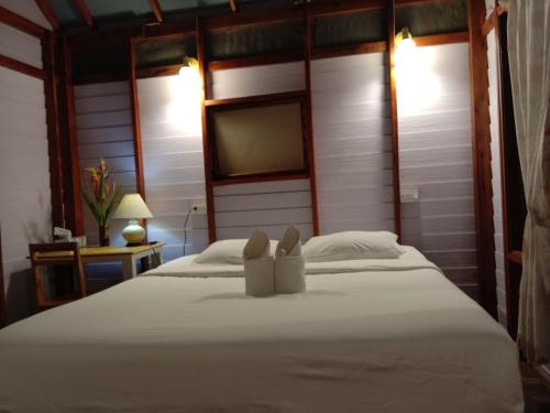 a bedroom with a bed with two shoes on it at Lazy Hut in Ko Phayam