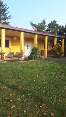 a yellow house with a lawn in front of it at Bungalow at Lake Alte Donau in Vienna