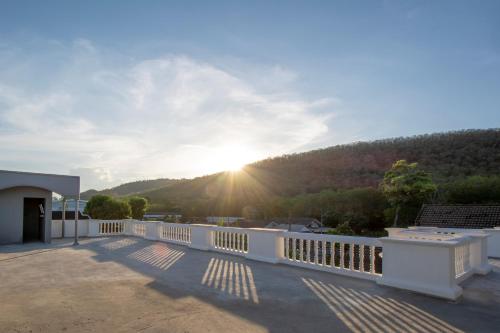 a view from the balcony of a house with the sun setting at Happiness Guesthouse in Pak Chong