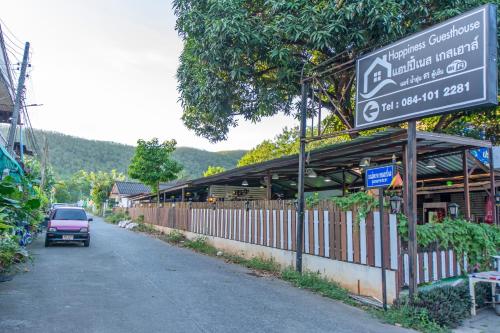 a building with a sign on the side of a street at Happiness Guesthouse in Pak Chong