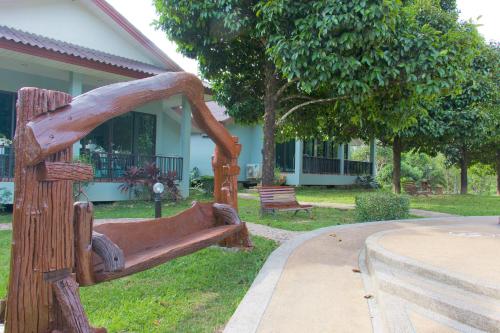 a wooden bench in front of a house at Akantuka Homestay in Chanthaburi