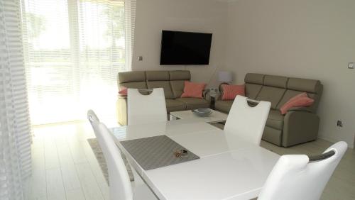 a living room with a white table and a couch at Apartament DeLux in Rewal