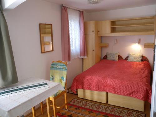 ザラカロシュにあるStudio in Zalakaros/Thermalbad 20673の小さなベッドルーム(赤いベッド1台、ベンチ付)